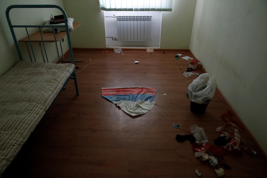 A cloth with the colours of Russian flag is seen on the ground in a cell at a preliminary detention centre.