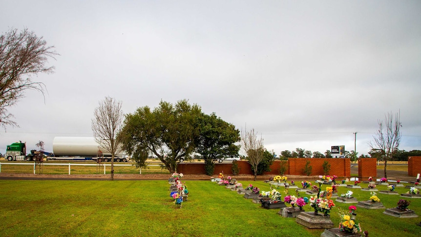 A truck roars past a children's cemetery.