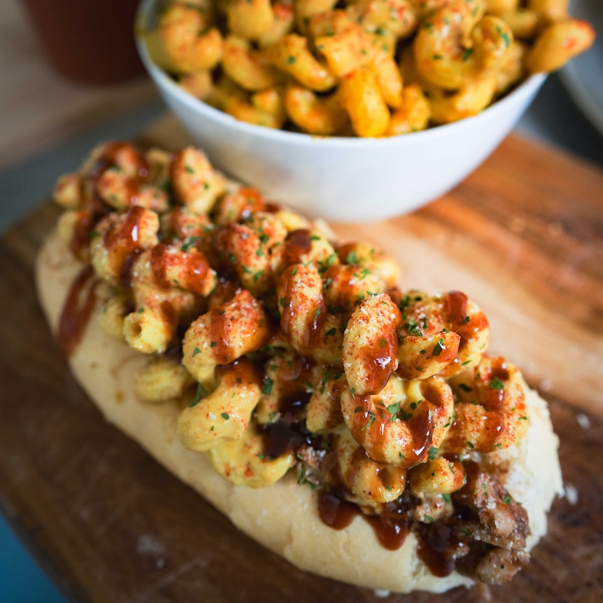 Jackfruit barbecue sandwich under a bed of macaroni and cheese with parsley, paprika, and barbecue sauce topping