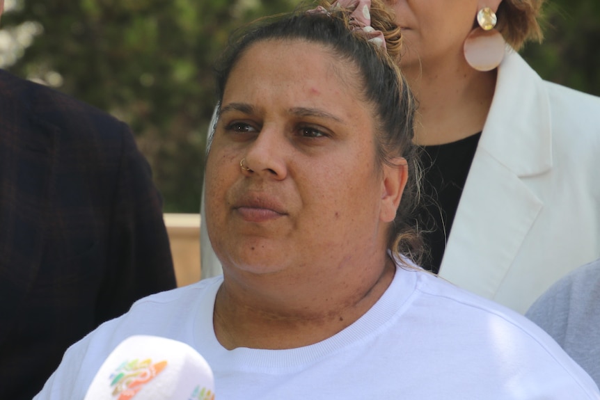 Mariah wears her hair tied up and a white Yale shirt as she addresses media