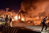 A car park is shown aflame, and police and a soldier are seen at the blast site.