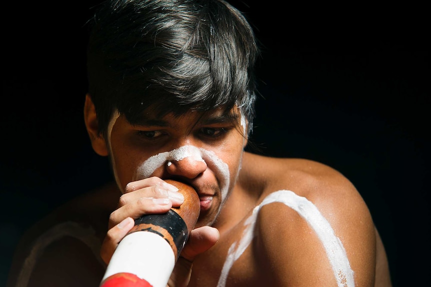 Bremer State High School student William Duncan plays the didgeridoo during a performance at the school, west of Ipswich.
