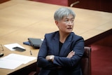 Penny Wong sits with her arms crossed in the Senate