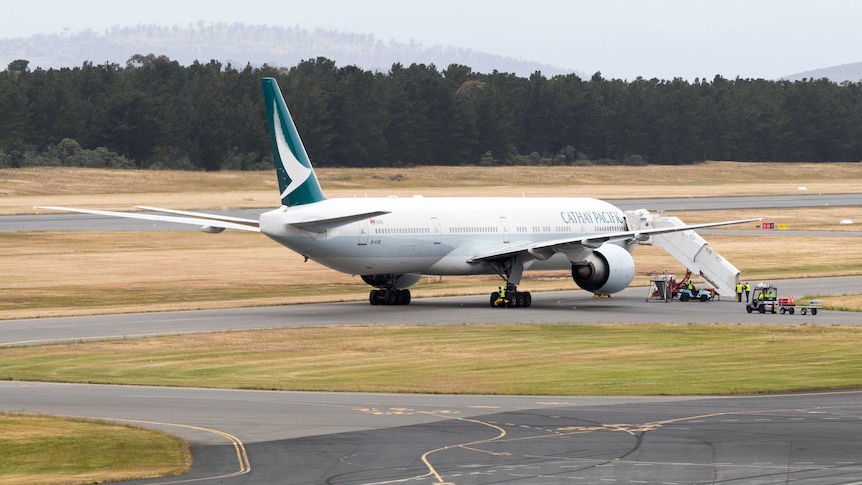 A Cathay Pacific jet parked on an airport runway.