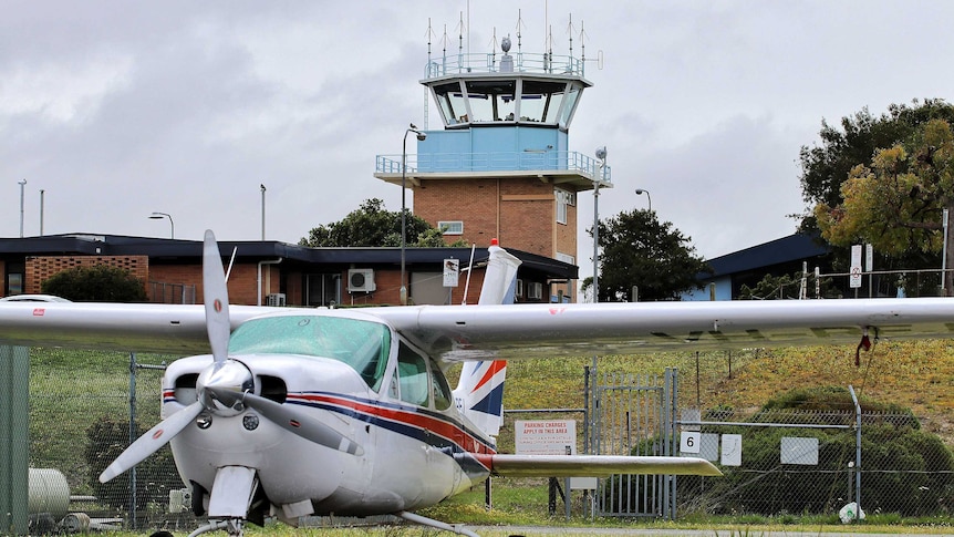 The control tower at a small airport, with a light plane in the foreground