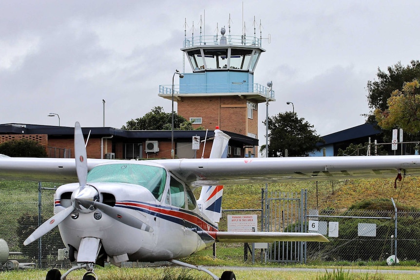 The control tower at a small airport, with a light plane in the foreground