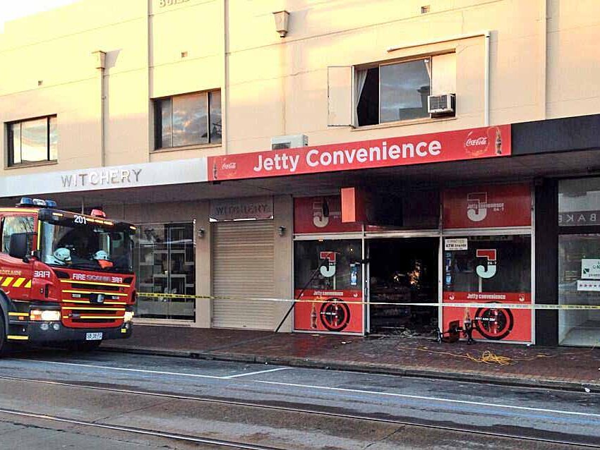 Police said two men in balaclavas tied up an attendant and set a store alight in Adelaide.