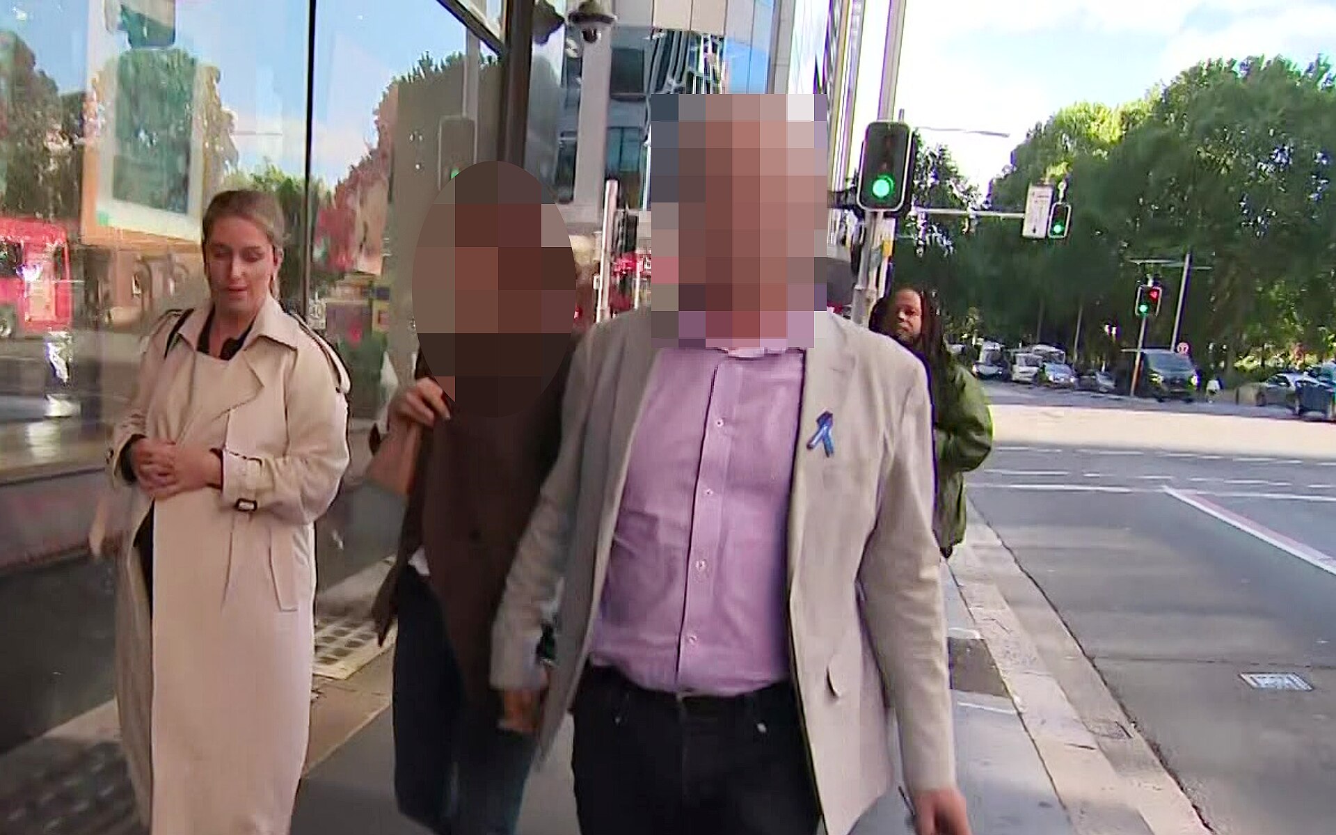 a blurred image of two people who were william tyrrell's foster parents walking on a street