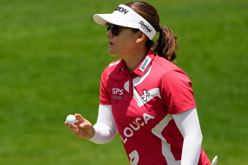 Hannah Green holds a golf ball