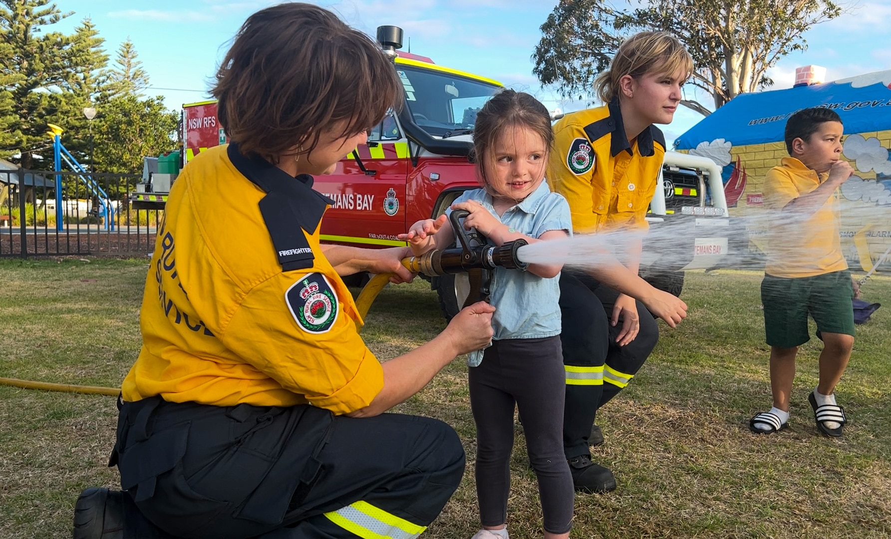 Kids operating a fire hose.
