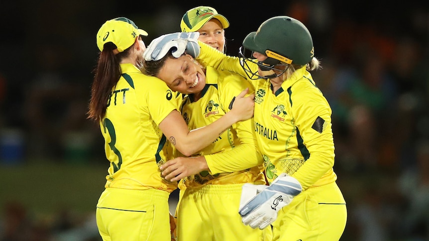 Four Australian players embrace as they celebrate a wicket at the ICC Women's T20 World Cup.