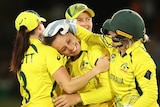 Four Australian players embrace as they celebrate a wicket at the ICC Women's T20 World Cup.