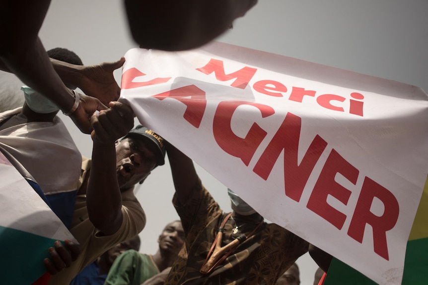 A protest in Africa where people hold a sign saying 'merci Wagner'