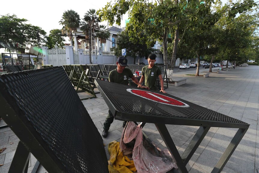 Police officers paint on barricades at the park near the residence of Cambodian's Prime Minister Hun Sen.