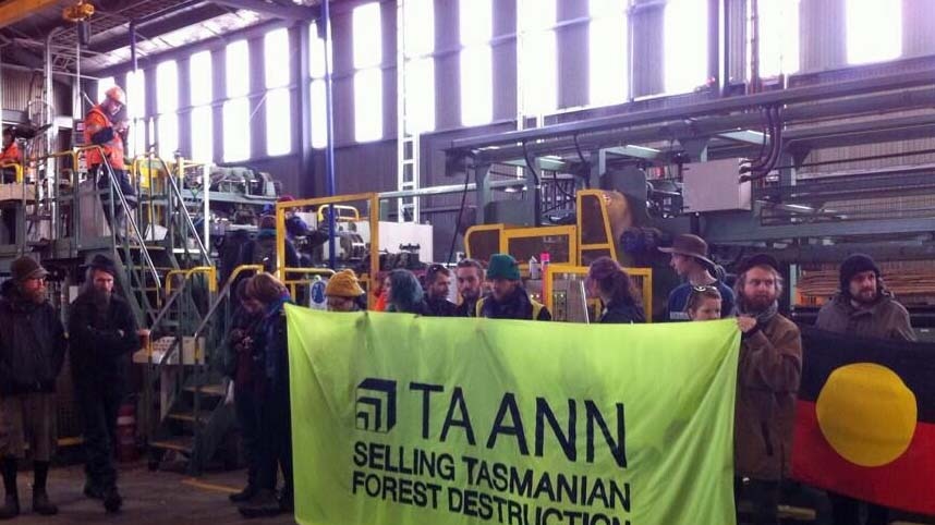 Forest activists hold a sign inside Ta Ann's Smithton sawmill in 2012.
