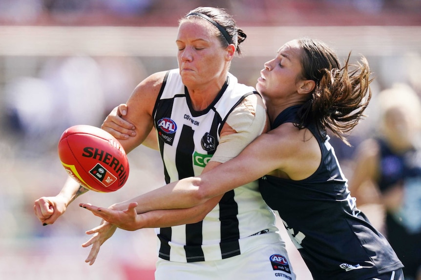 Stacey Livingstone gets a handball away while being tackled.