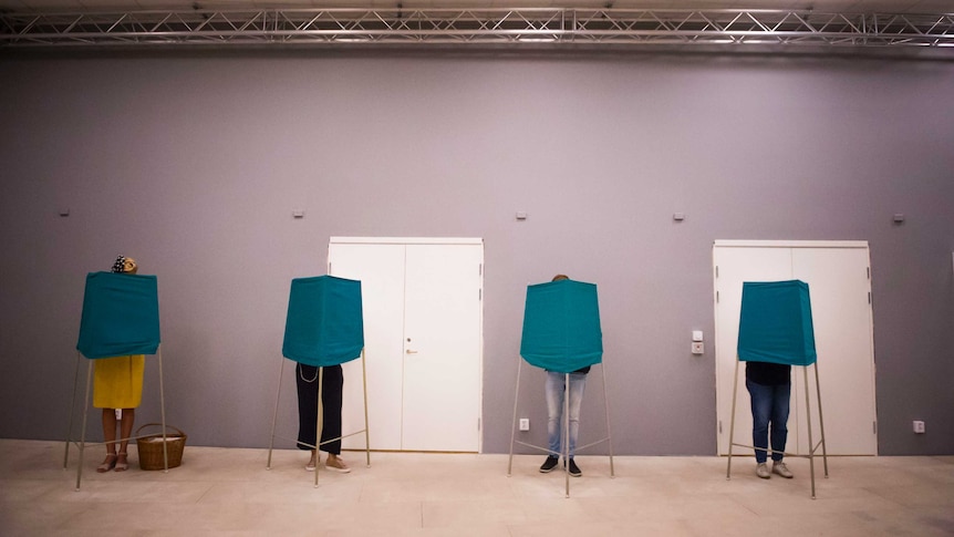 People vote in behind temporary polling booths in Sweden