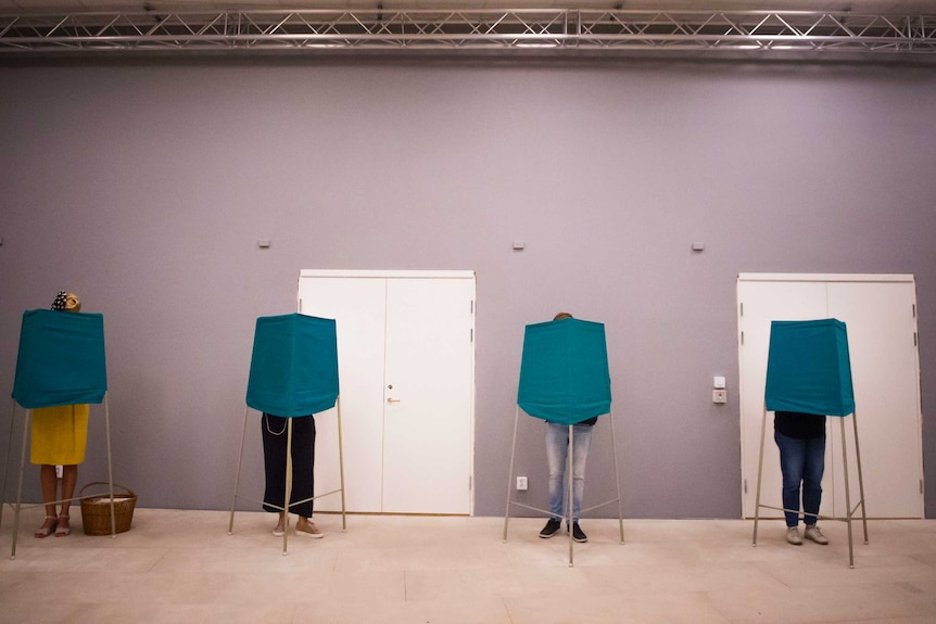 People vote in behind temporary polling booths in Sweden