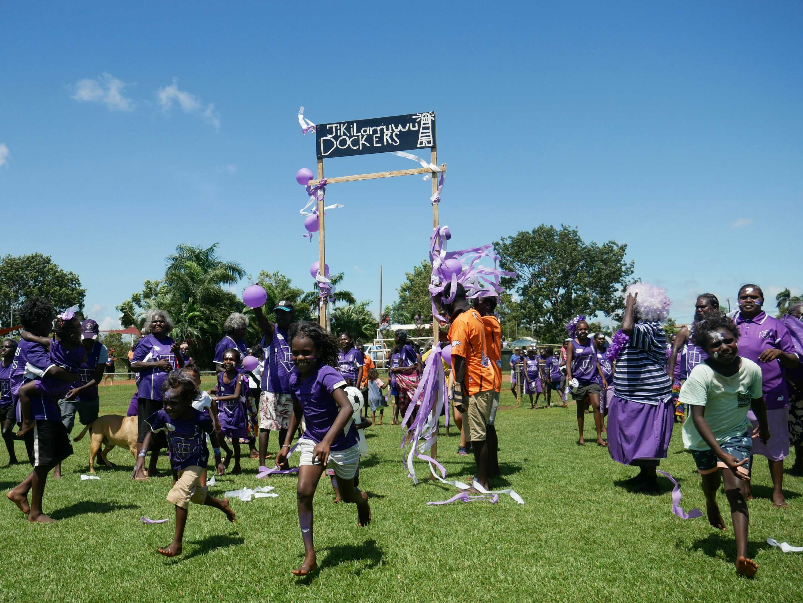 Jikilarruwu Dockers fans run onto the field as the football grand final gets underway.