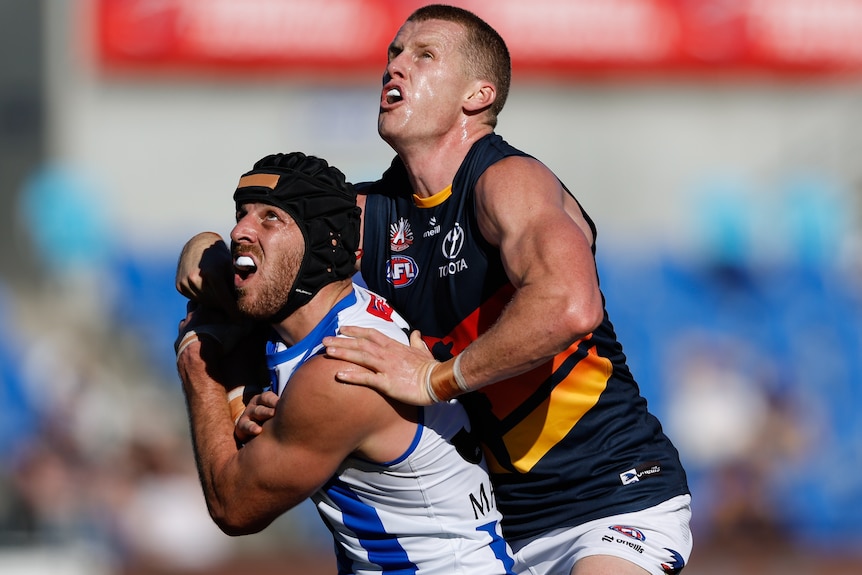 Tristan Xerri of the Kangaroos and Reilly O'Brien of the Crows compete in a ruck contest.