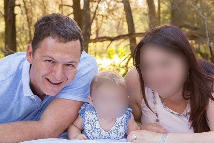 Francois Schwartz smiling with the blurred faces of his child and wife