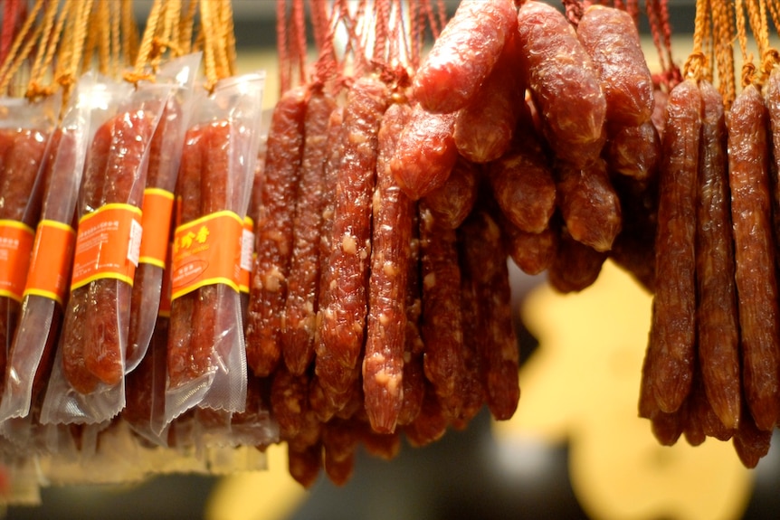 Bunches of red-coloured Chinese sausages (called lap cheong) hanging to dry.