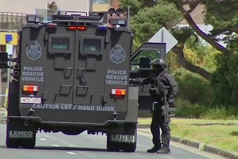 A police rescue vehicle and heavily armed police in Rye, where a man is believed to be holed up with two people in a cafe.