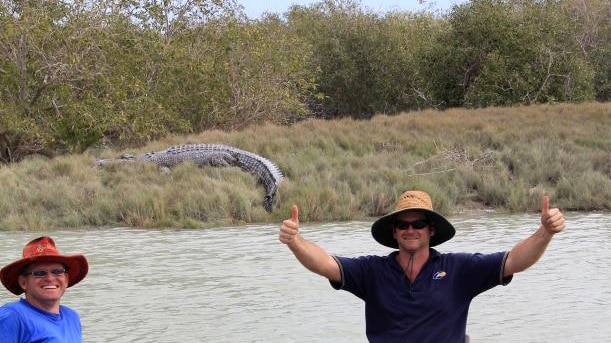 Fishermen with a crocodile in the background.