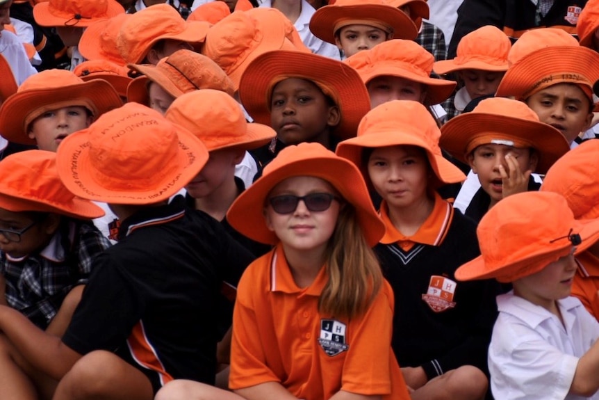 Students sit cross-legged at a school assembly at John Henry Primary School, in Melbourne's south-east.