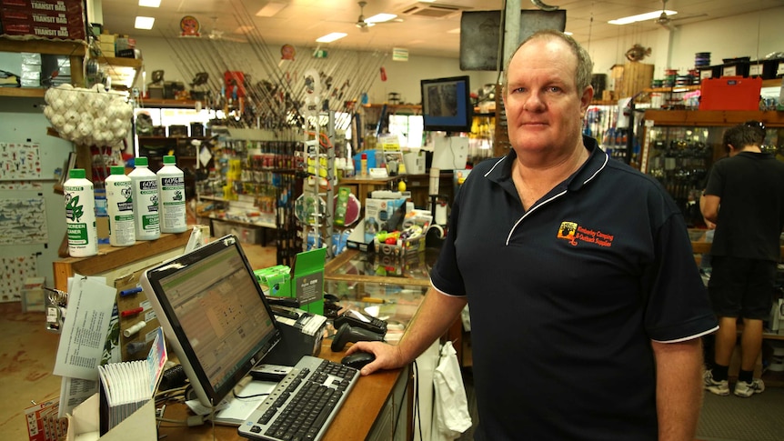 Bruce Bechly stands at a computer in his fishing shop which was targeted by cyber attackers.