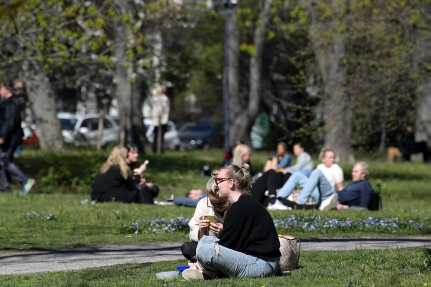 People eat lunch in Humlegarden park in Stockholm, Sweden.