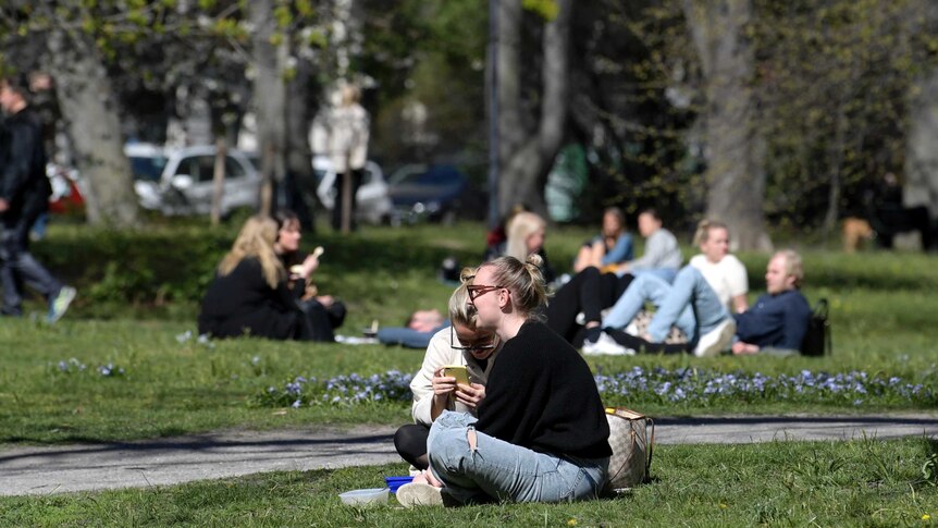 People eat lunch in Humlegarden park in Stockholm, Sweden.