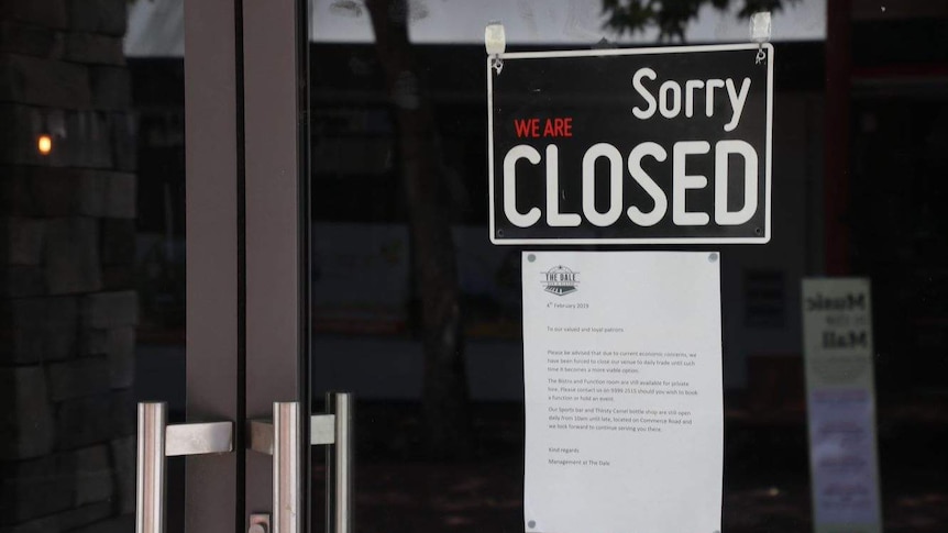 'Closed" sign on the front of a door.