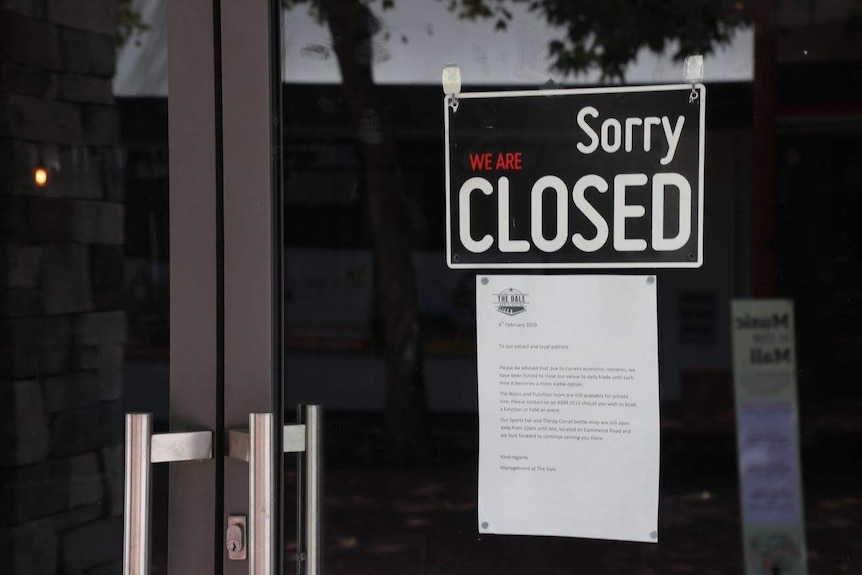 'Closed" sign on the front of a door.