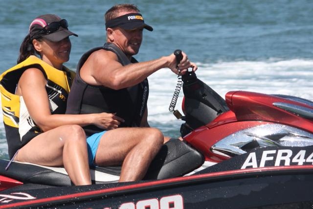 a man on a jet ski with a woman sitting behind him