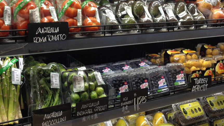 Supermarket stand stocked with fruit and vegetables