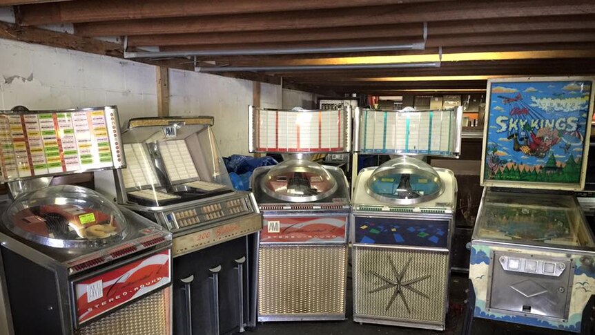 Jukeboxes and pinball machines in a warhouse.