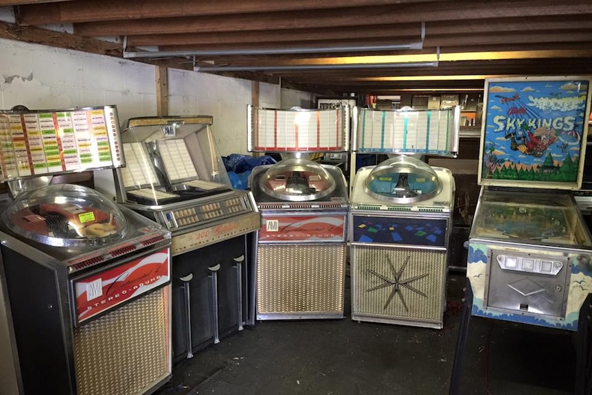 Jukeboxes and pinball machines in a warhouse.