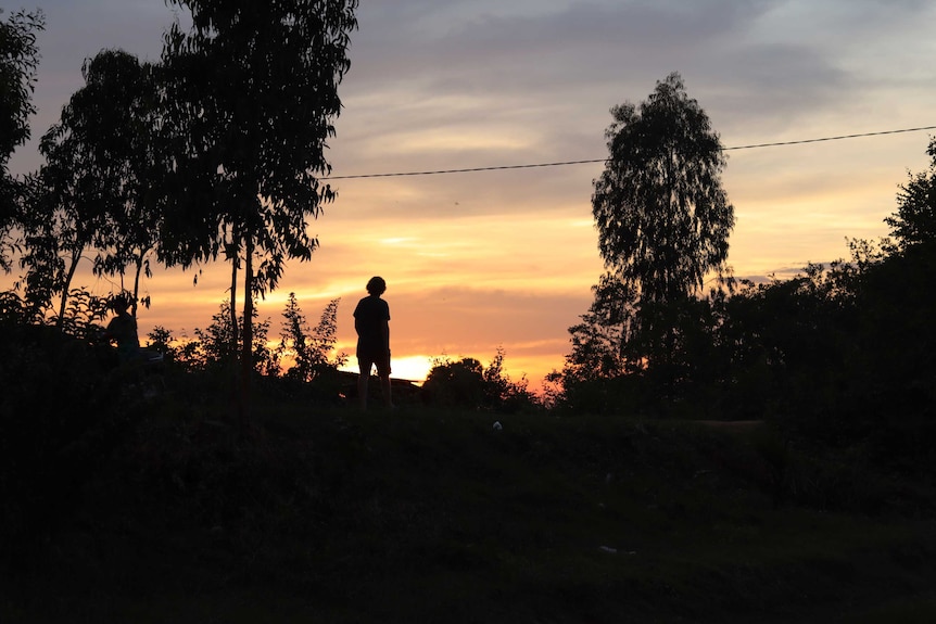 The silhouette of a man in the foreground of a sunset