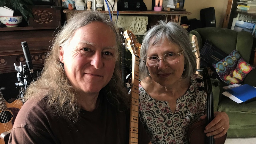 Musicians Steve and Marjorie Gadd sitting at their home in Franklin amongst many musical instruments