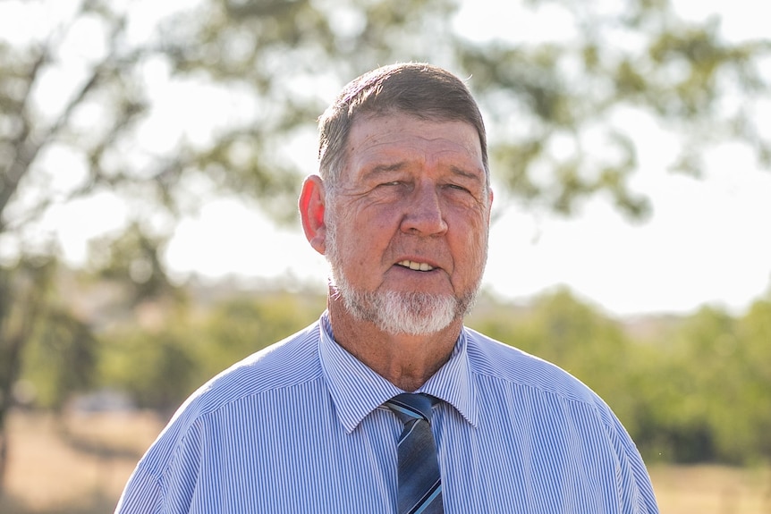 man in a blue shirt and tie smiling 