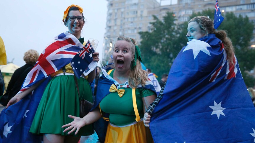 3 girls wearing green and gold and australian flag capes arrive at the exhibition centre in Kiev