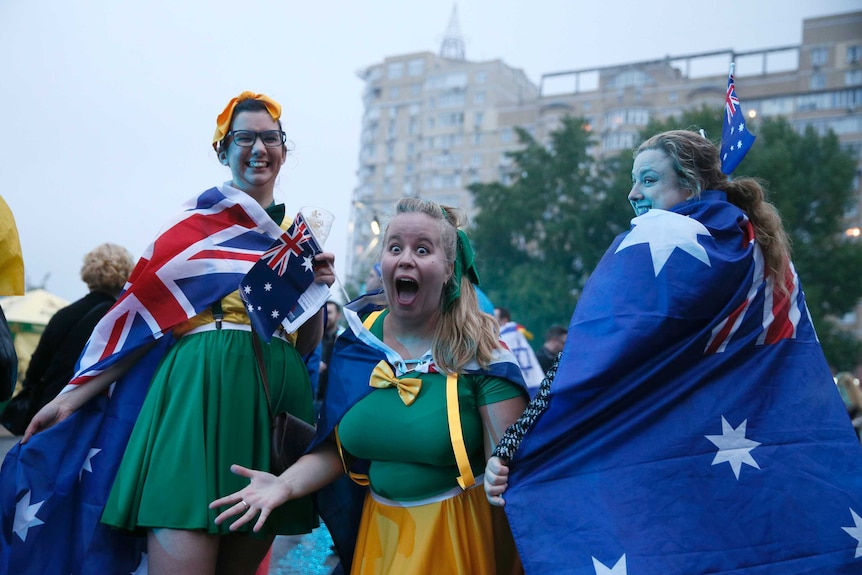 3 girls wearing green and gold and australian flag capes arrive at the exhibition centre in Kiev