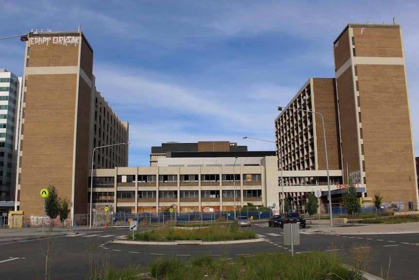 Two large towers connected by a smaller building that used to be office space but are now abandoned and vandalised.