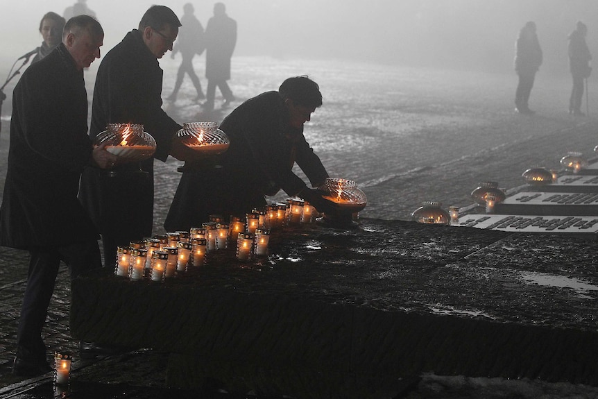 Candles placed at monument to Auschwitz victims