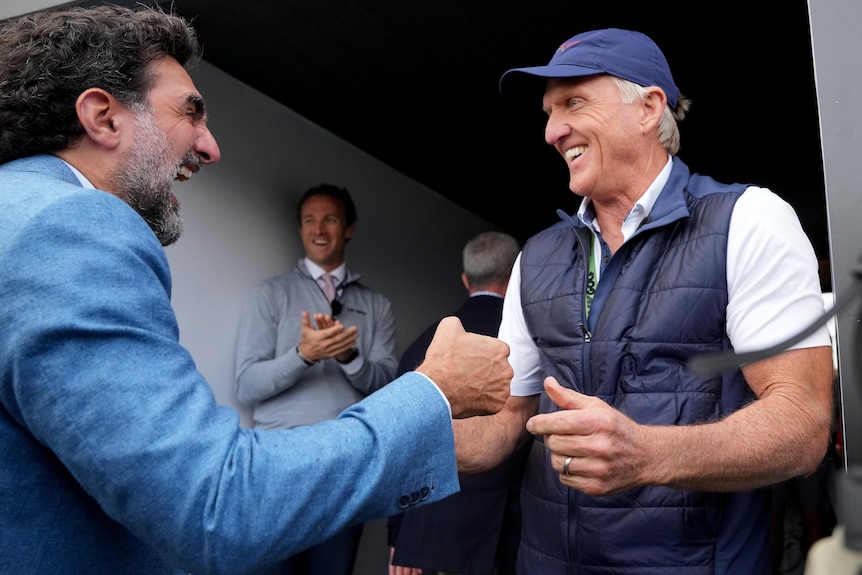 Two men involved in a controversial golf tournament shake hands