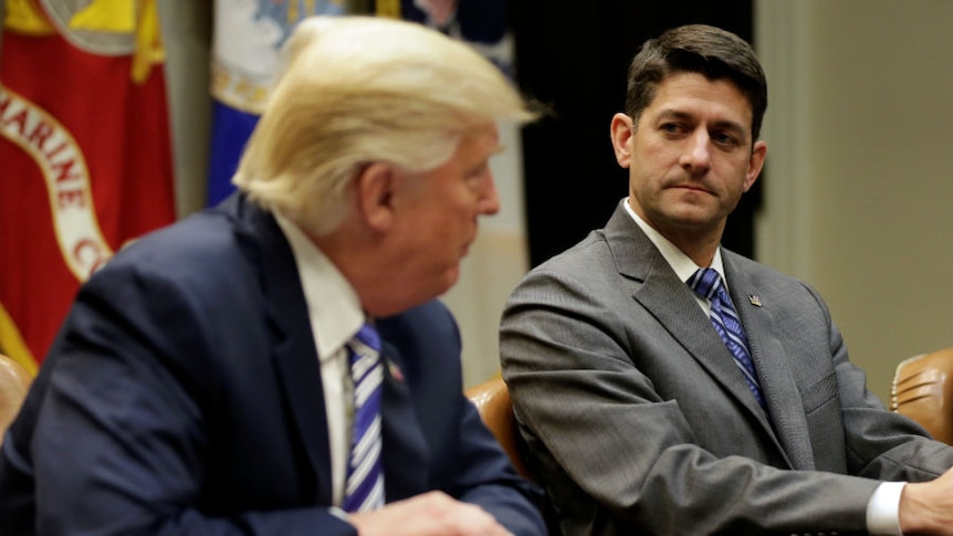 Speaker of the House Paul Ryan listens as U.S. President Donald Trump speaks
