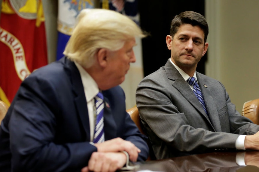 Speaker of the House Paul Ryan listens as U.S. President Donald Trump speaks