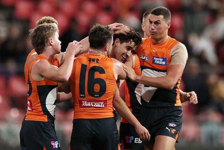 Toby Bedford is mobbed by teammates after kicking a goal