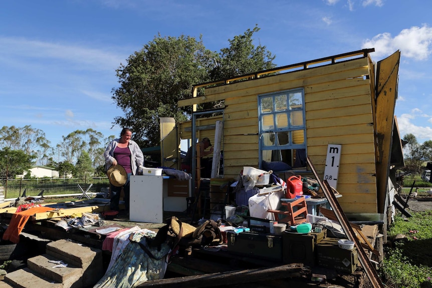 A woman stands on the slab of her destroyed house in Marmor, Queensland